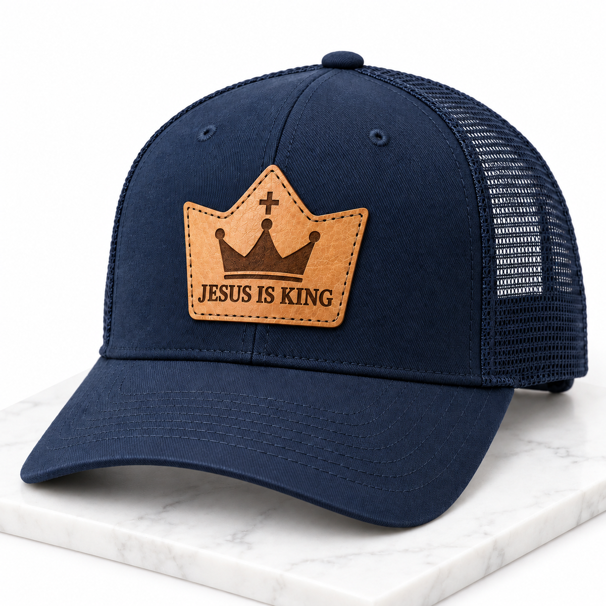 Jesus Is King leather patch trucker hat on white tile
