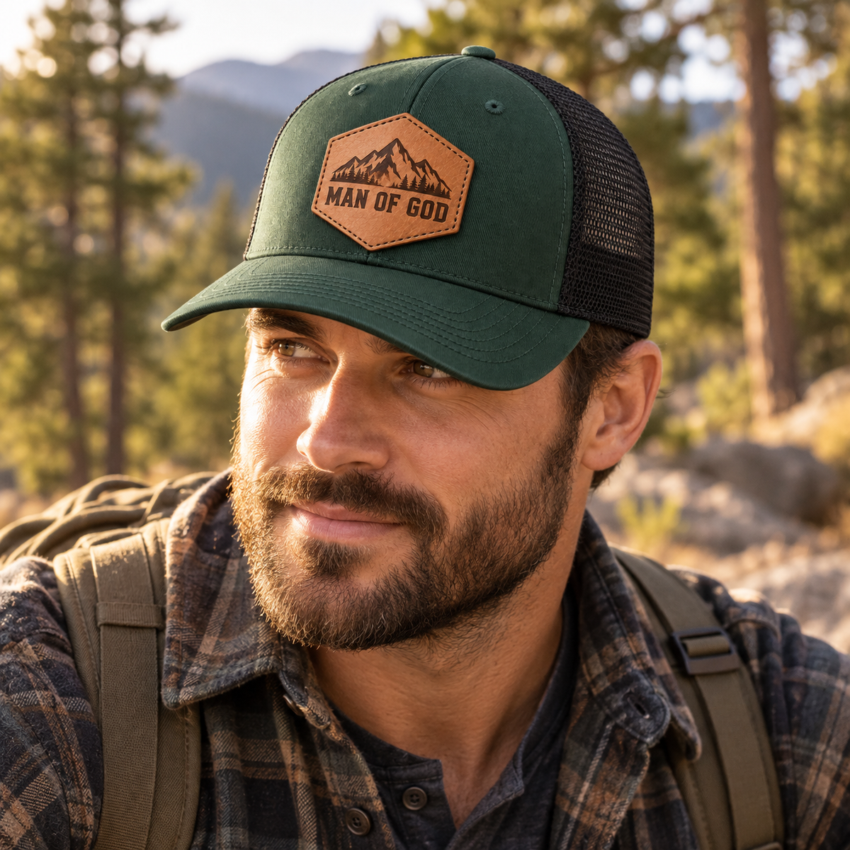 Adult model wearing Man of God mountain leather patch green trucker cap